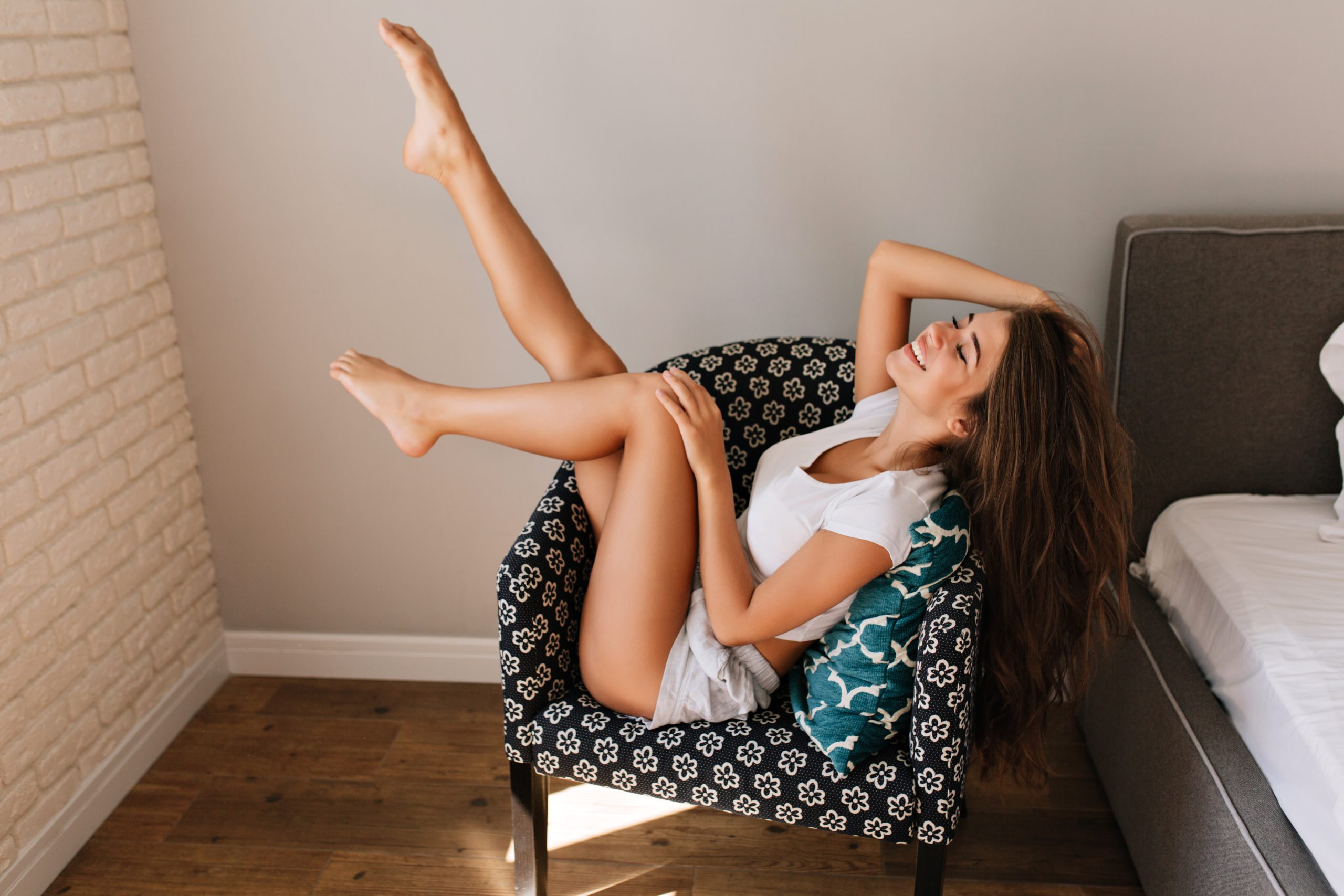 pretty young girl with long hair shirts chilling chair she holds legs smiling with closed eyes scaled